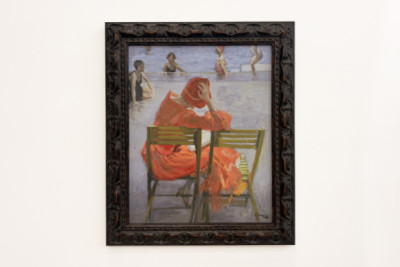 Chica con vestido rojo leyendo junto a una piscina