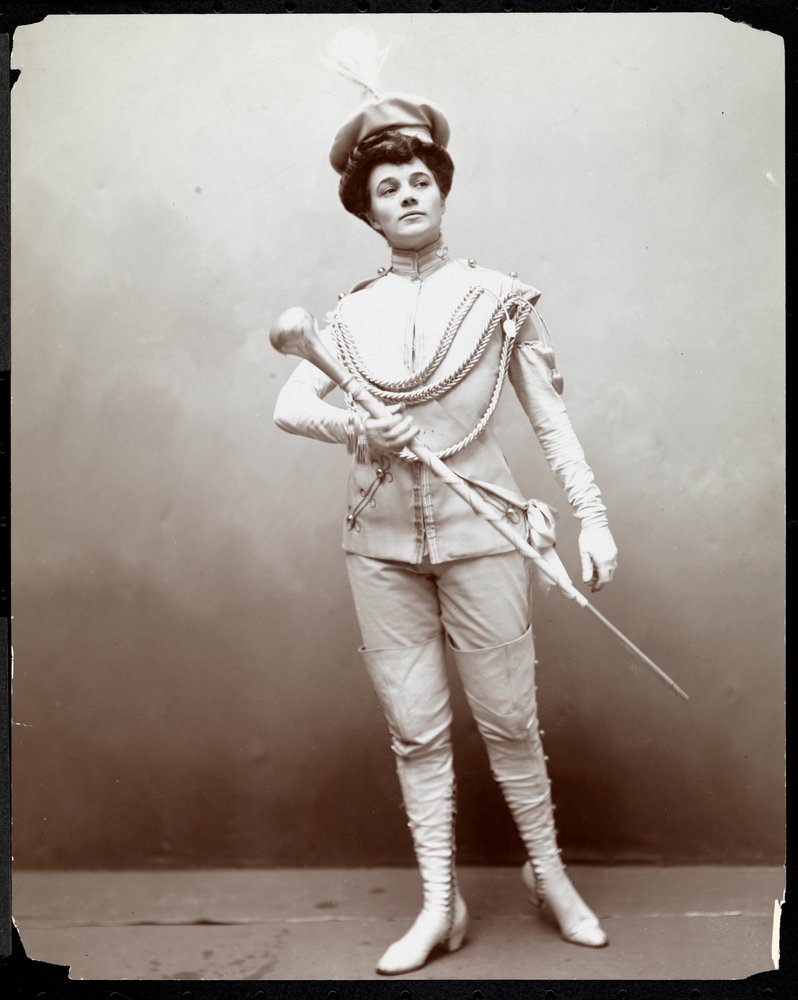 Una mujer modelando un uniforme de banda, sosteniendo una batuta, c.1898 de Byron Company