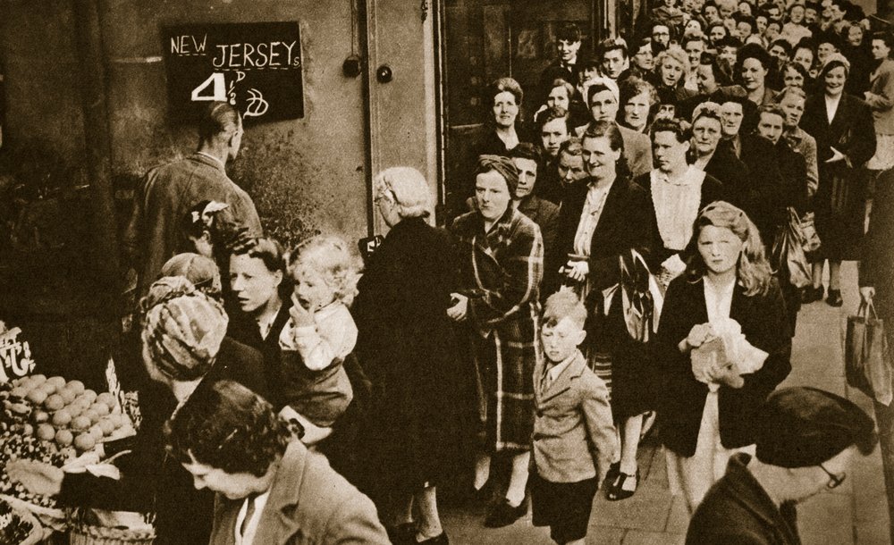 Mujeres hacen cola ante un puesto de frutas y verduras en Londres, junio de 1947 de English Photographer