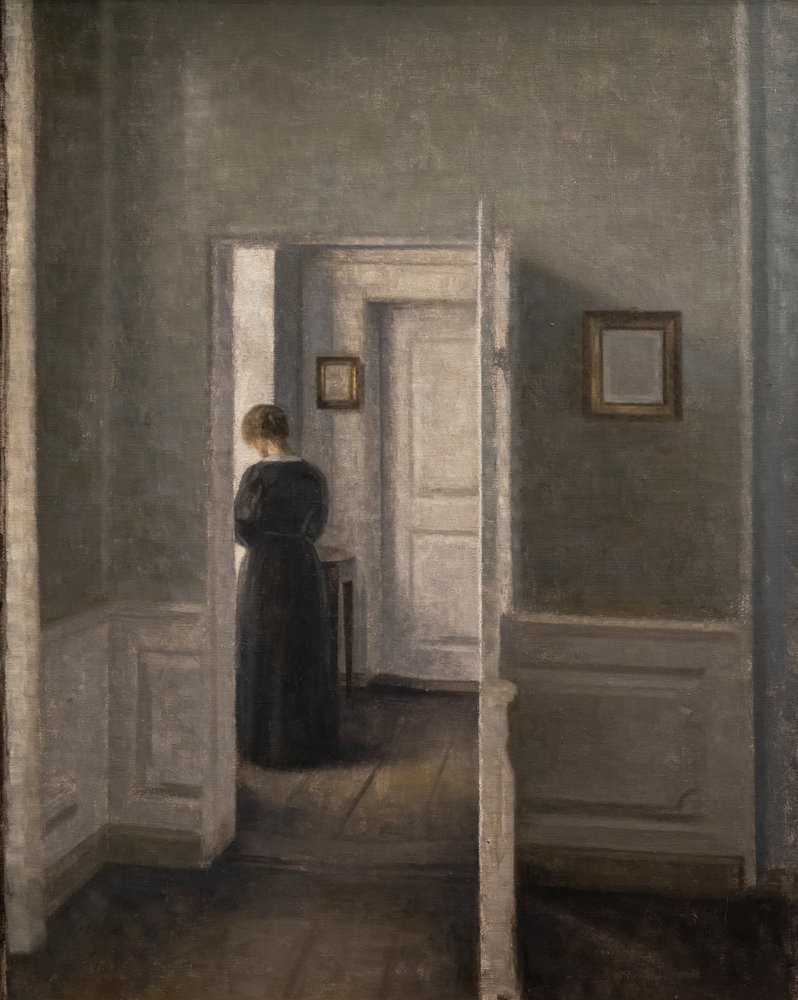 Interior con una mujer de pie de Vilhelm Hammershoi