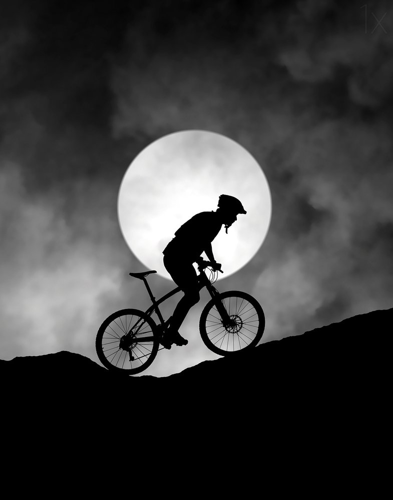 Ciclista de montaña a la luz de la luna de Hengki Lee