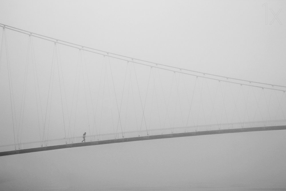 Paseo solitario por un puente envuelto en niebla de Krunoslav Nevistic