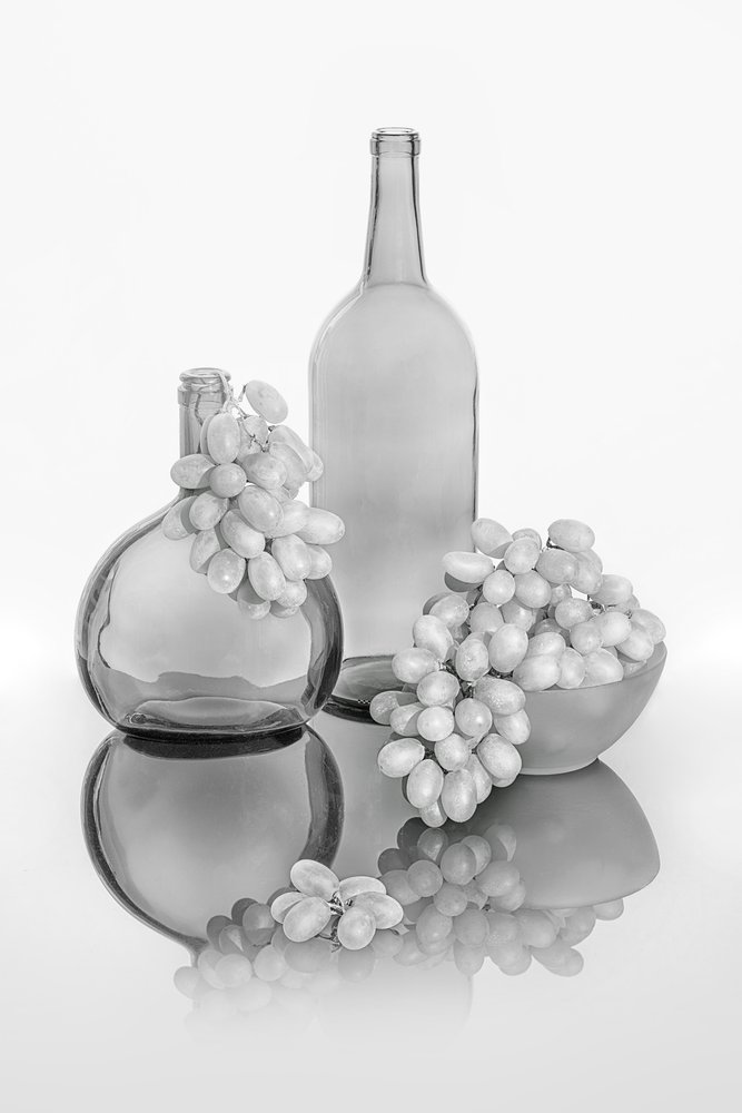 Botellas de cristal con uvas monocromáticas de Lydia Jacobs