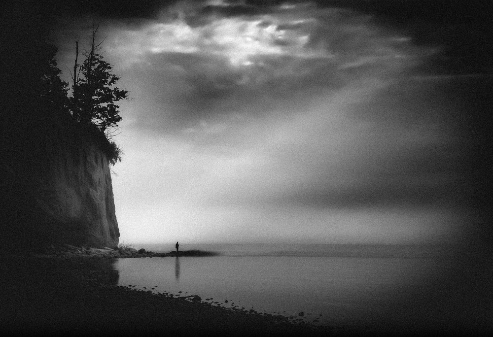 Una figura solitaria en la costa brumosa de Monika Zemojtel