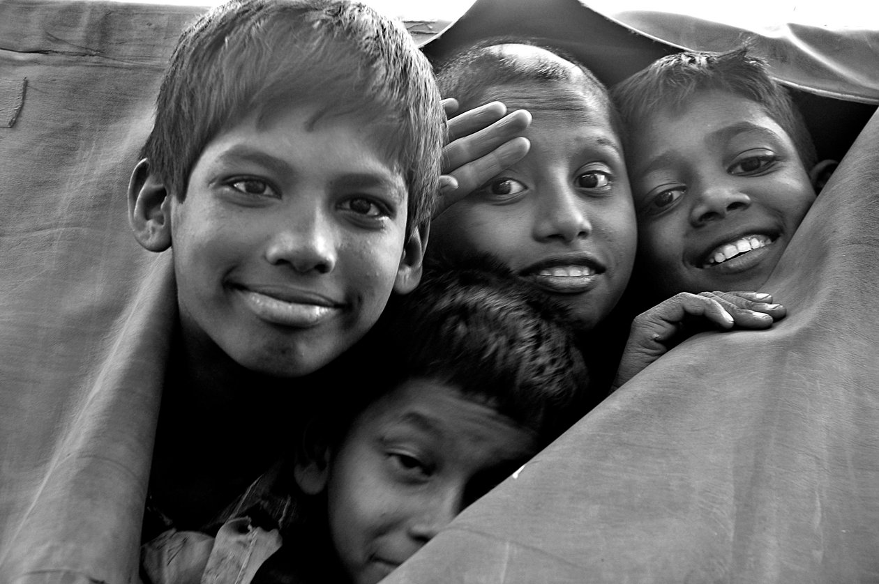 Niños indigentes miran a través de una lona rota de una furgoneta policial en la ciudad de Dhaka, Bangladesh. 26 de noviembre de 2006 de Unknown