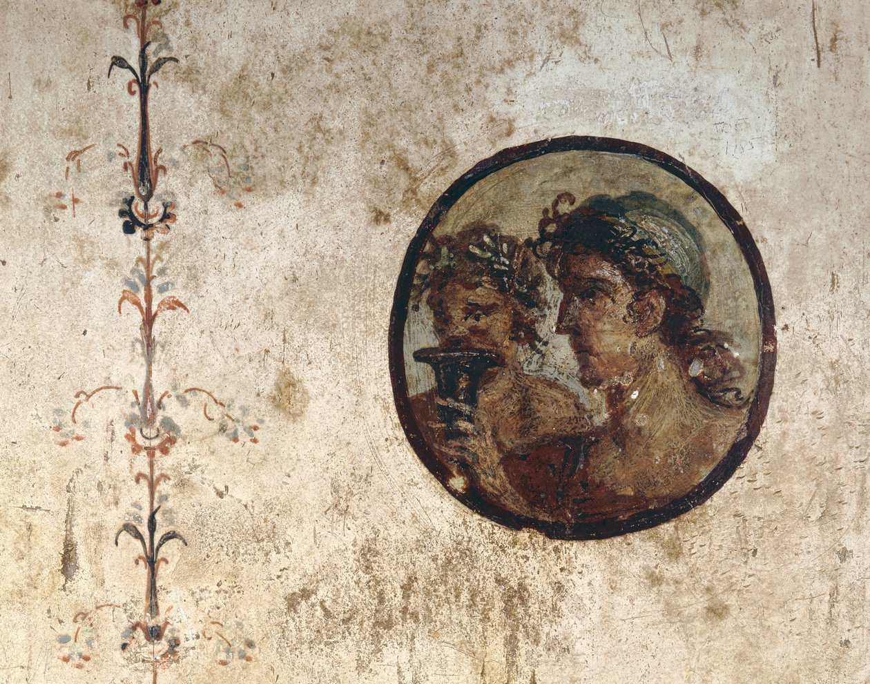 Interior de una habitación con frescos en las paredes del período romano, Estilo III, en la Casa de Corieo Tiburtino en Pompeya: parte de una vid y un tondo con dos cabezas masculinas de Unknown