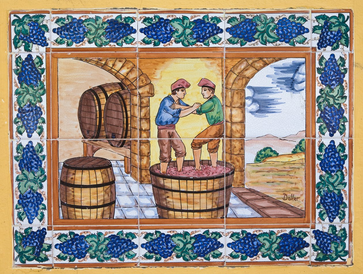 Azulejos cerámicos españoles modernos al estilo del siglo XVII o XVIII que muestran a trabajadores pisando uvas en una tina en la bodega del viñedo de Unknown
