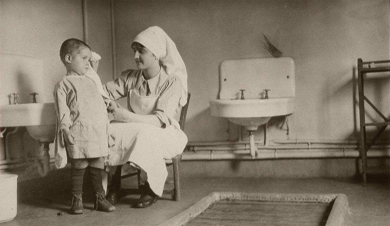 Enfermera atendiendo a un niño enfermo en las colonias de Passay y Saint-Quentin para refugiados y huérfanos, 1919 de American Photographer
