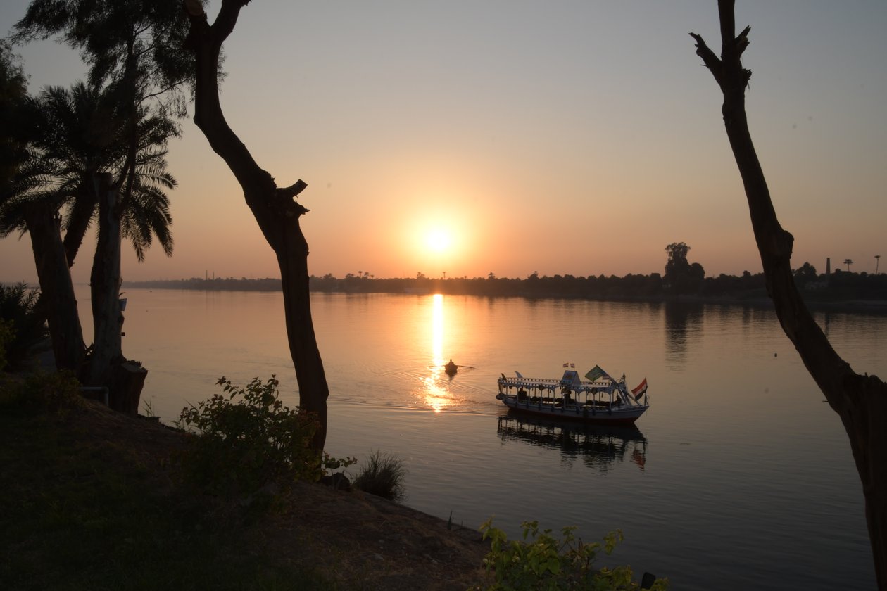 Reflejos dorados del atardecer en un río tranquilo de Albert Mansour