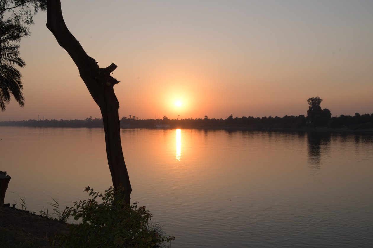 Reflejos dorados del atardecer en un río tranquilo de Albert Mansour