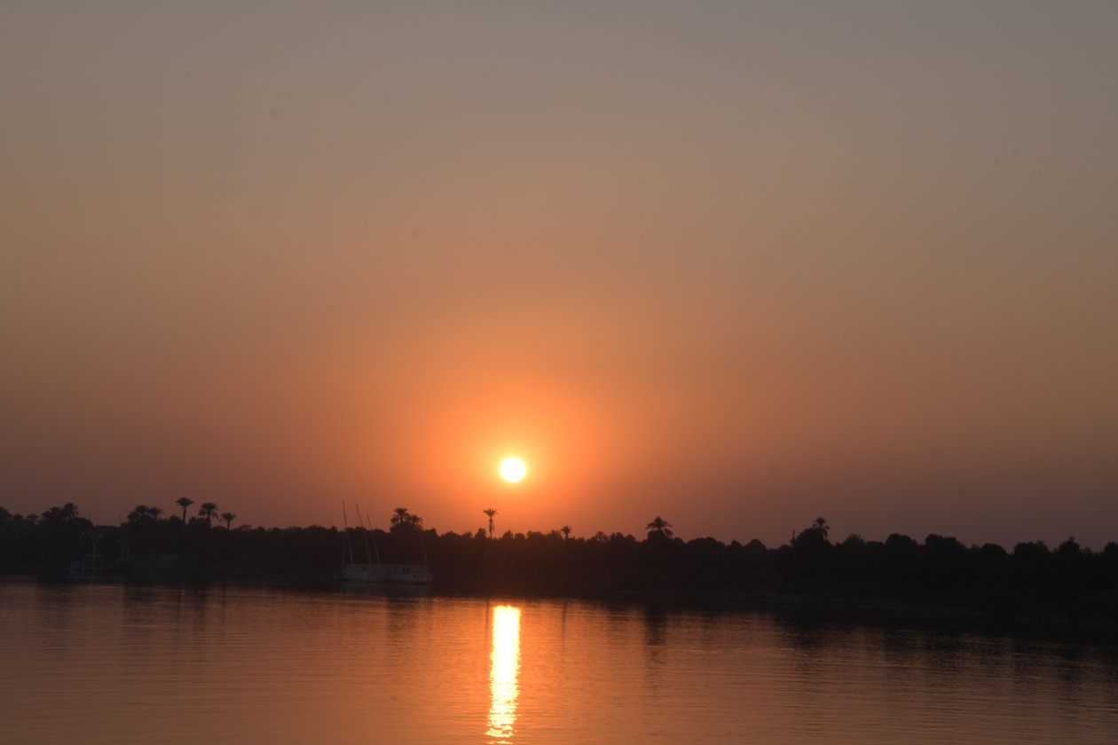 Reflejos dorados del atardecer en un río tranquilo de Albert Mansour