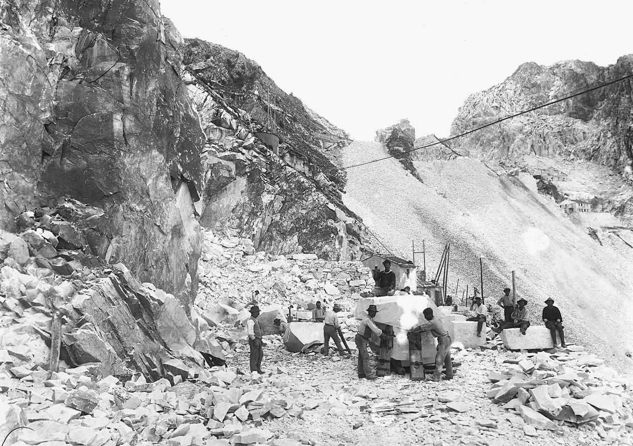 Excavadores trabajando en una cantera de mármol en los Alpes Apuanos, Toscana. Algunos están sentados en bloques de mármol ya cuadrados. de A. Corsini