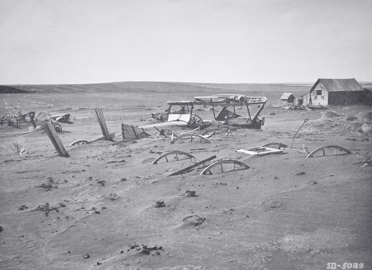 Coche y maquinaria agrícola enterrados por polvo y arena, Dallas, Dakota del Sur de American Photographer