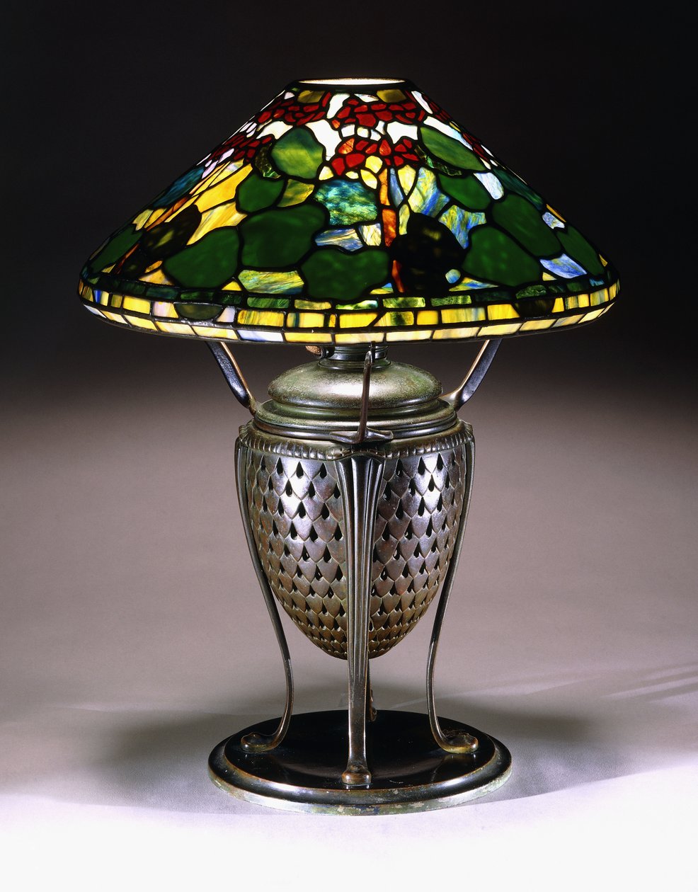 Lámpara de mesa "Geranio" con pantalla cónica y base de urna de bronce reticulado con patrón de escamas de pez, siglo XX de American School