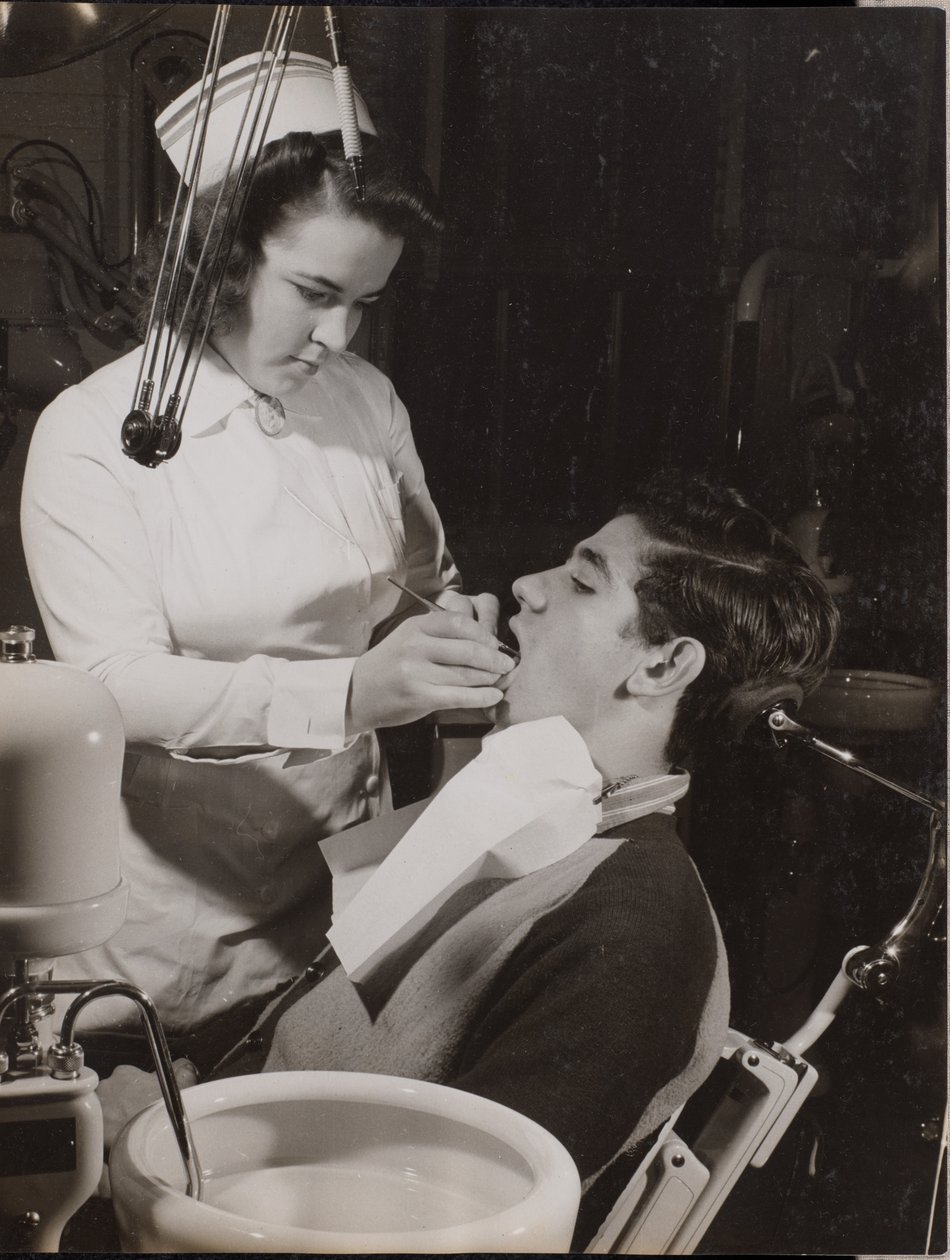 [Higienista dental inspecciona la boca de un paciente] de Arnold Eagle