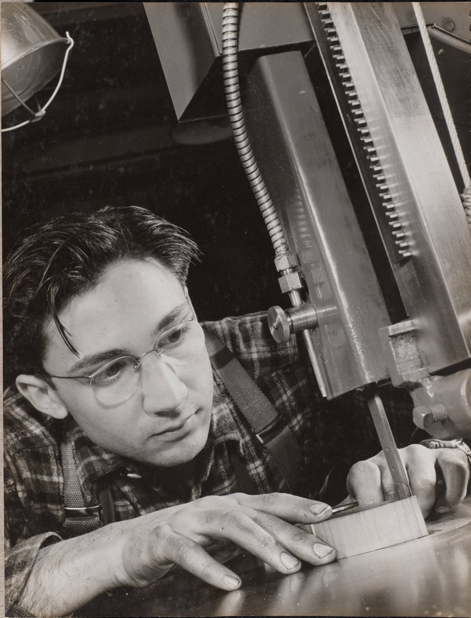 [Hombre con gafas trabaja atentamente con una lima industrial] de Arnold Eagle