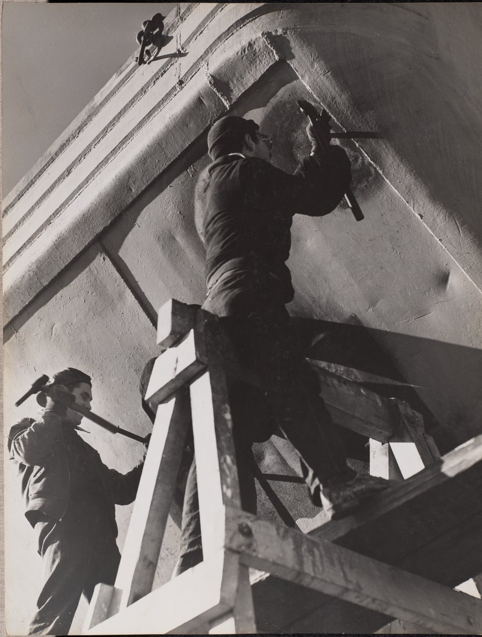 [Dos hombres trabajan en la parte inferior de un barco] de Arnold Eagle