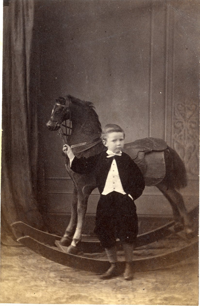 Niño de pie sosteniendo las riendas de un caballo de juguete, 1860s (impresión de albúmina) de Barat