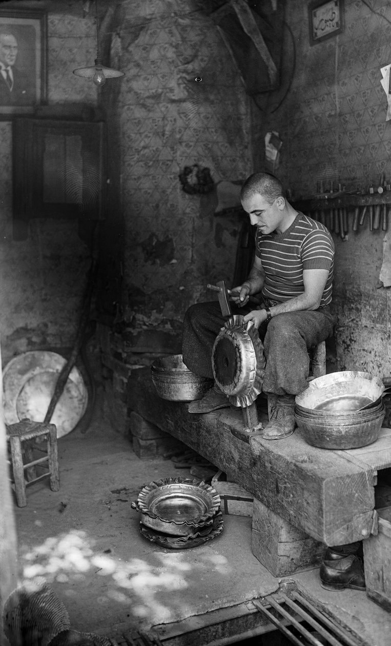 Metalúrgico italiano martilleando sobre una chapa encofrada para fabricar una vasija u olla elevada, Italia de Bernard F. Rogers