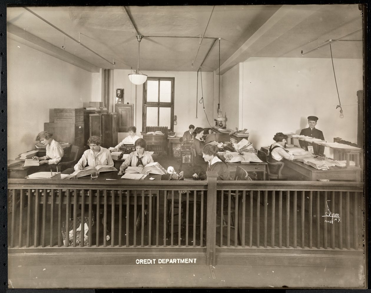 Un hombre y una mujer trabajando en la oficina de crédito de la Mantle Lamp Co. de América, Nueva York, 1915-16 de Byron Company
