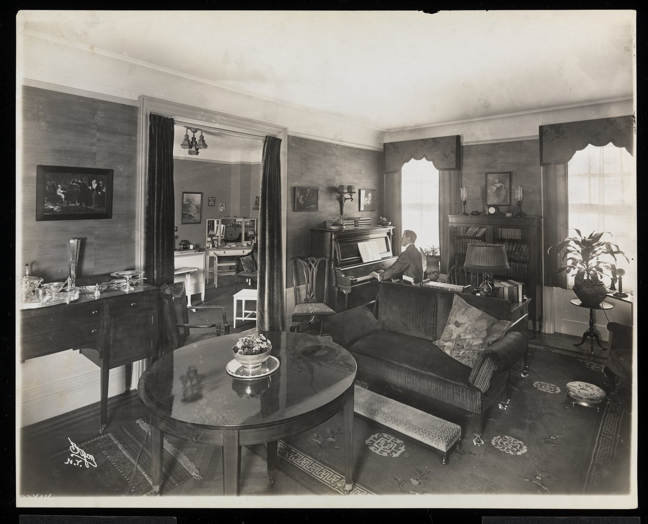 Un hombre tocando el piano en una sala de estar de la residencia de A.C. Cronin, 1915-16 (impresión de gelatina de plata) de Byron Company