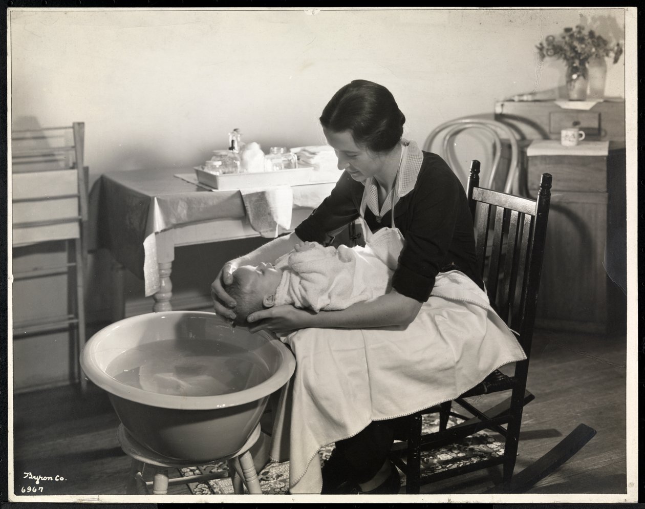 Una mujer lavando la cabeza de un bebé en el Centro de Maternidad en 211 East 57th Street, Nueva York, 1934 de Byron Company