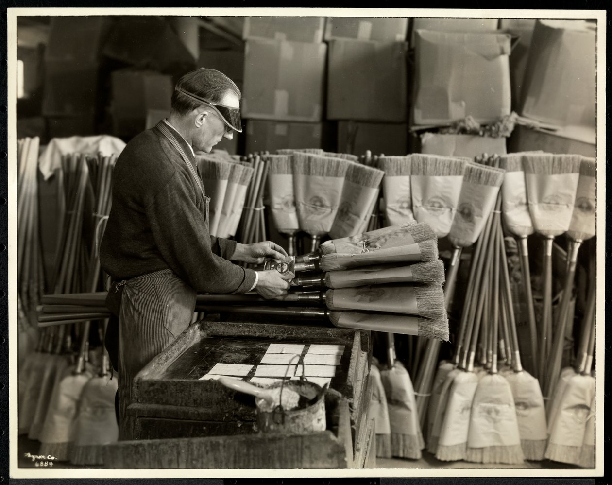 Hombre ciego etiquetando escobas en el Edificio Conmemorativo Bourne, Nueva York, 1935 de Byron Company