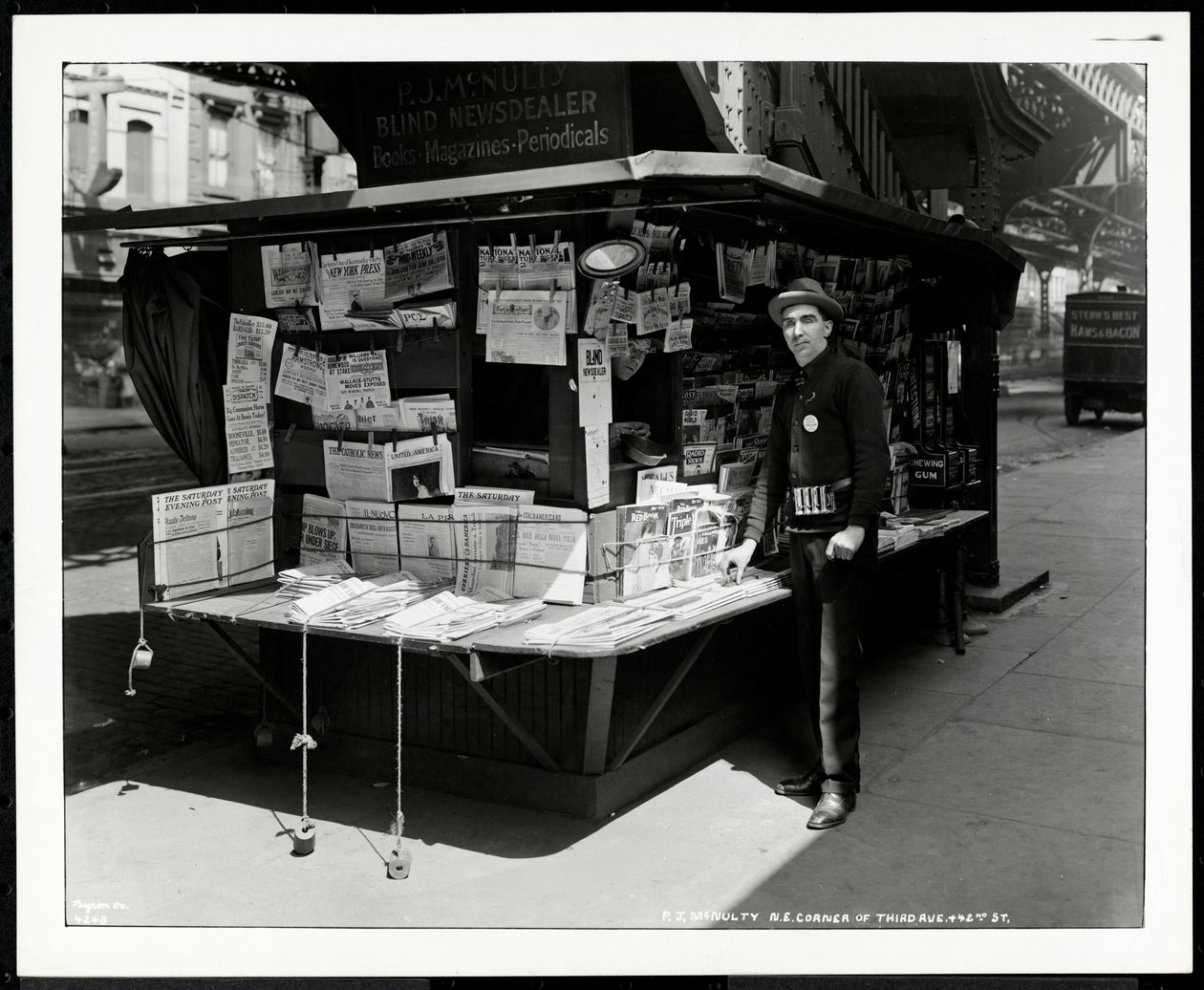 Vendedor de periódicos ciego P.J. McNulty en su puesto en la esquina noreste de 3rd Avenue y 42nd Street, Nueva York, 1926 de Byron Company