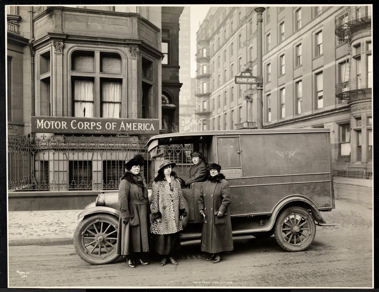 Cuatro mujeres del Cuerpo de Motor de América frente a una ambulancia en Park Avenue en la calle 40 frente al edificio del Cuerpo de Motor de América, Nueva York, 1920 de Byron Company