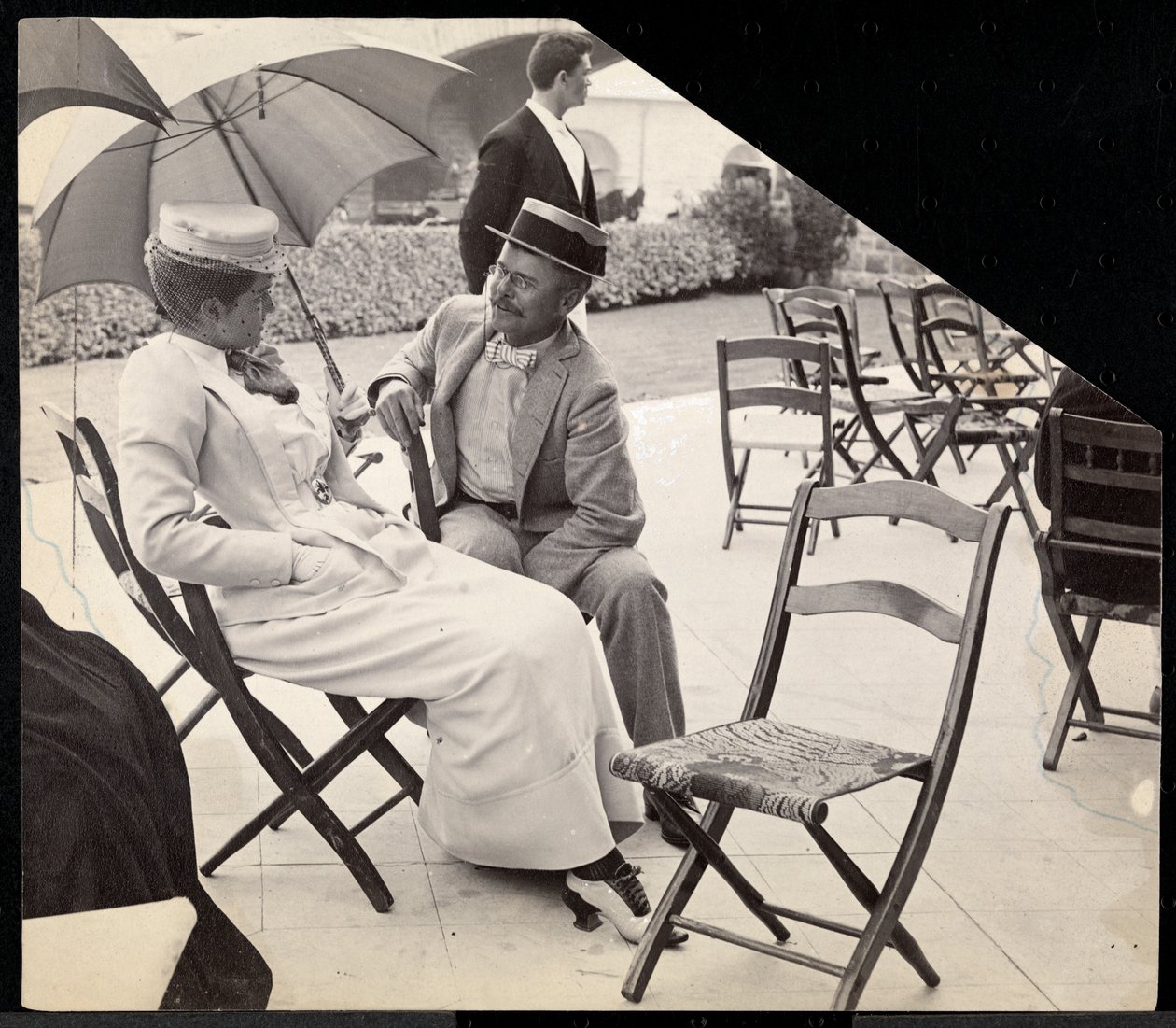 Hombre y mujer sentados afuera en sillas plegables con mujer sosteniendo una sombrilla, Narragansett, Rhode Island, 1891 (impresión de gelatina de plata) de Byron Company