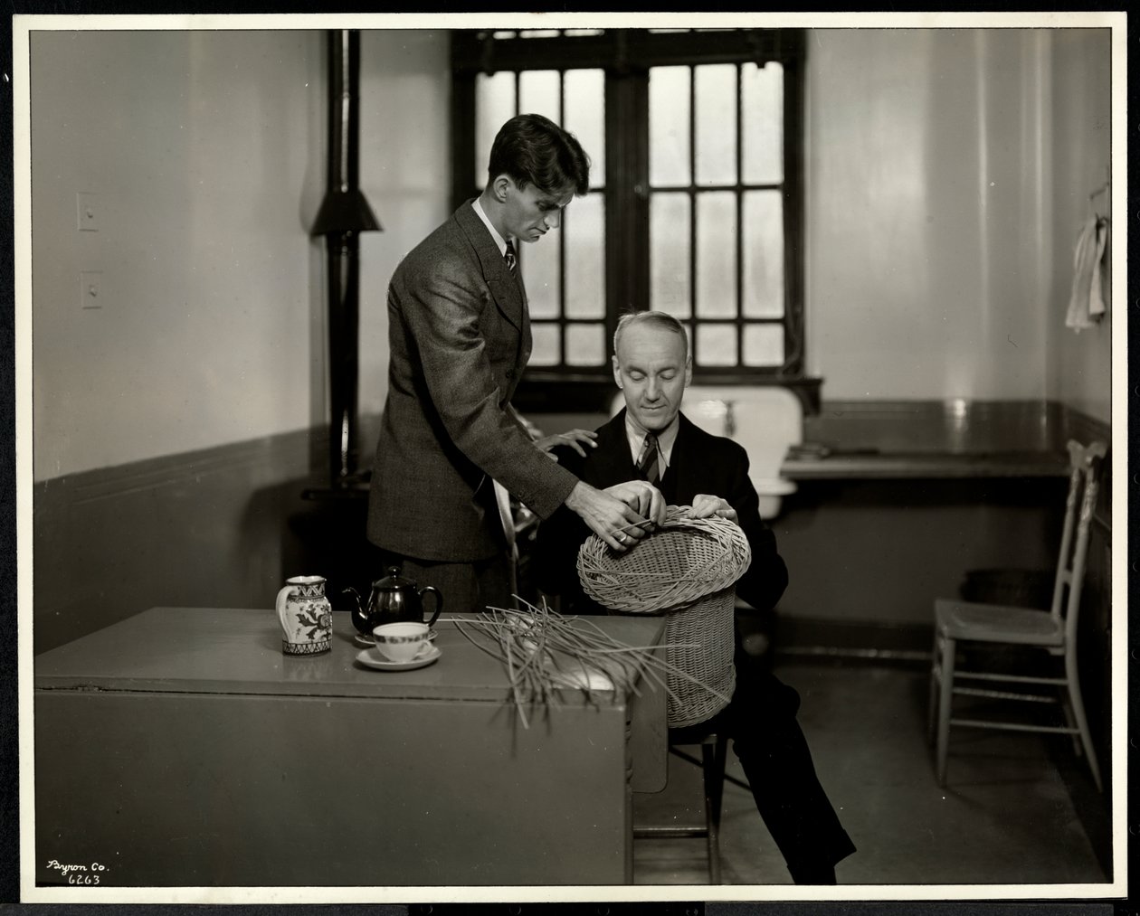 Hombre enseñando a otro hombre a hacer cestas en la Asociación para Ciegos de Nueva York, 111 East 59th Street, Nueva York, 1931 de Byron Company