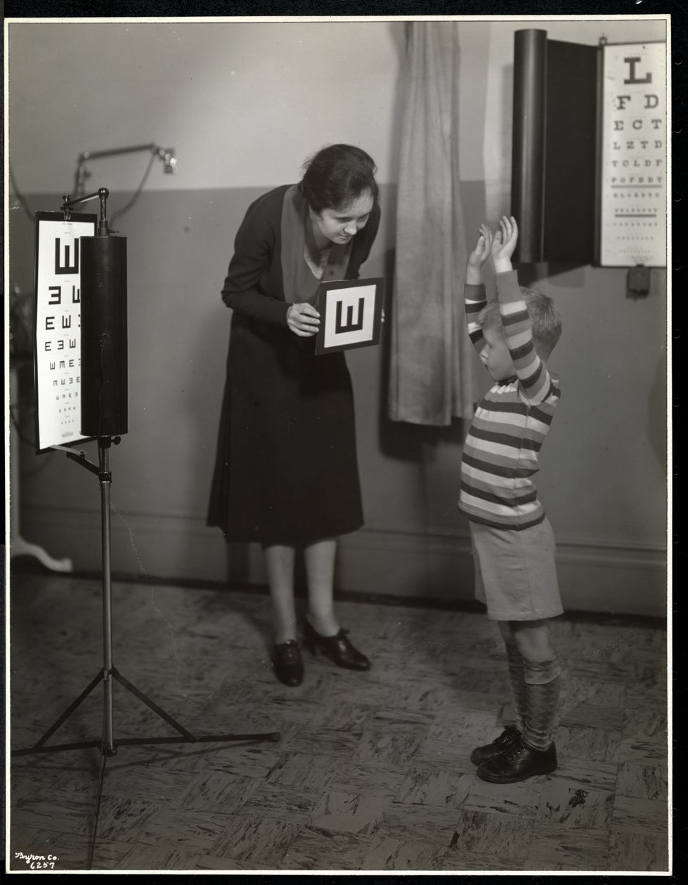 Enfermera y un niño paciente haciéndose una prueba ocular en la Asociación para Ciegos de Nueva York, 111 East 59th Street, Nueva York, 1930 de Byron Company