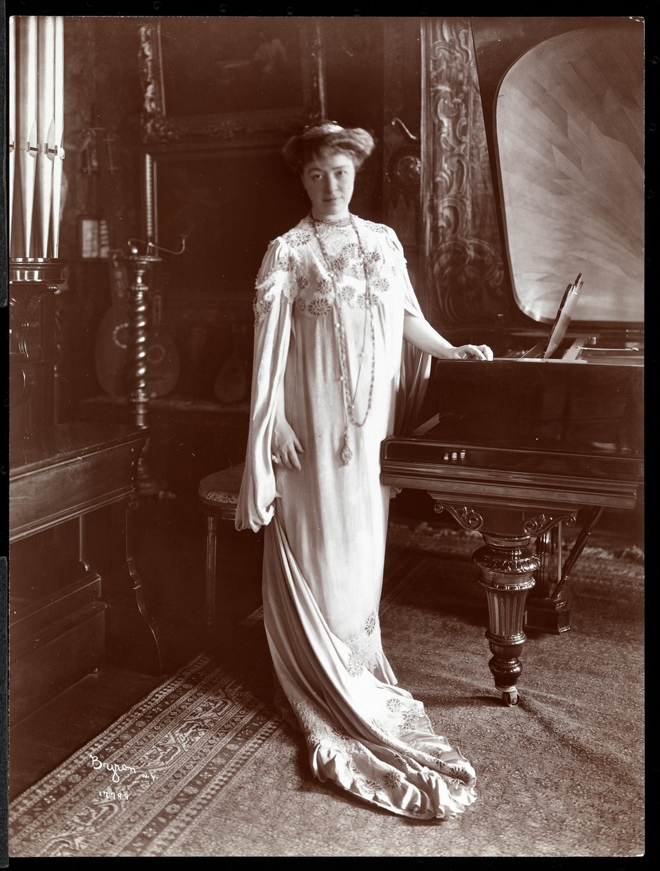 Retrato de la Sra. I. M. Clark de pie junto a un piano, 1904 de Byron Company