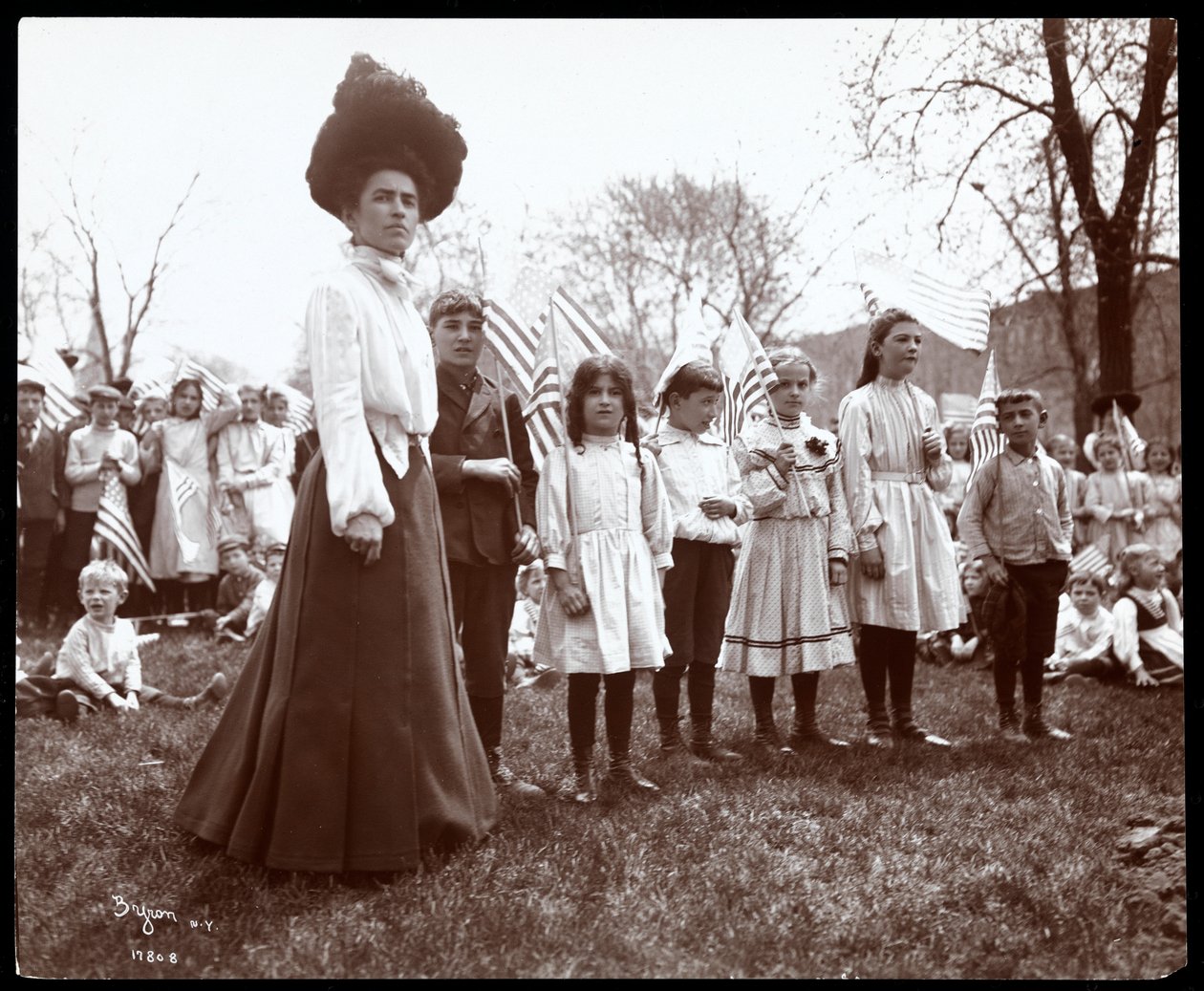 Mujer con niños sosteniendo banderas en el Día del Árbol en Tompkins Square Park, Nueva York, 1904 de Byron Company