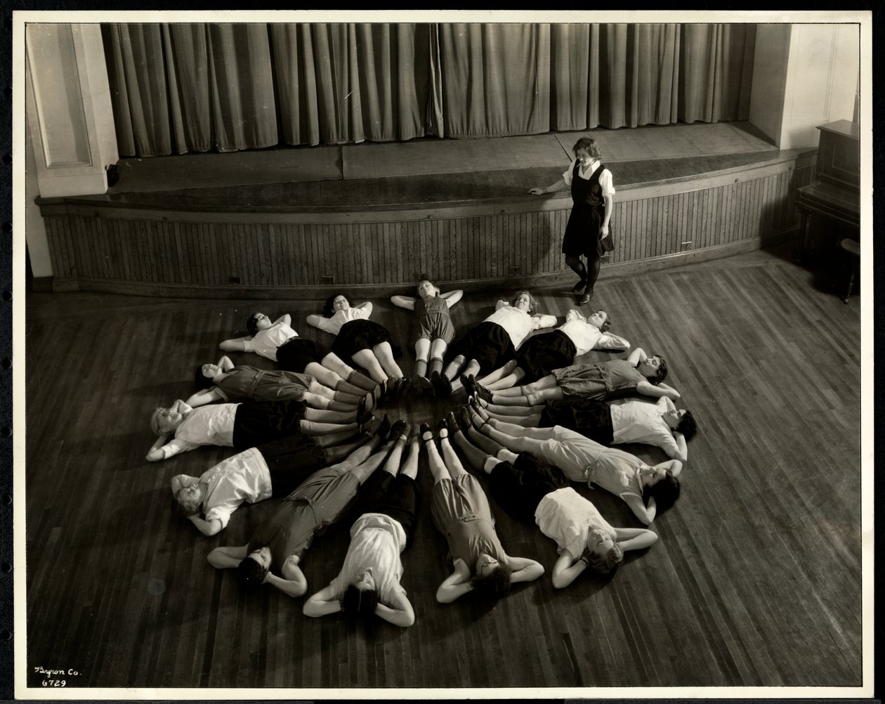 Mujeres jóvenes ciegas acostadas en un patrón de estrella en el piso del gimnasio en la Asociación para Ciegos de Nueva York, 111 East 59th Street, Nueva York, 1933 de Byron Company