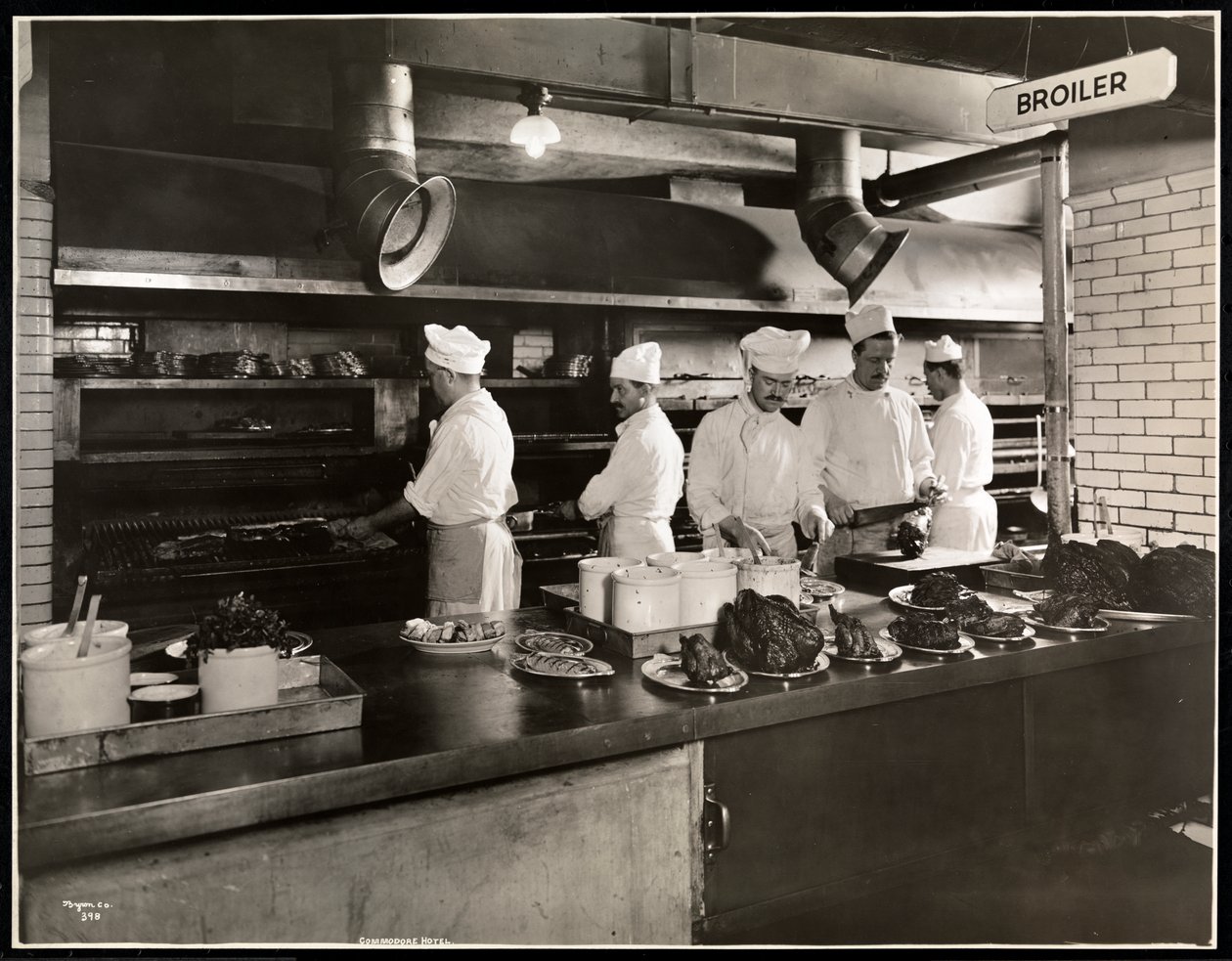 Cocineros en la parrilla en la cocina del Hotel Commodore, 1919 de Byron Company