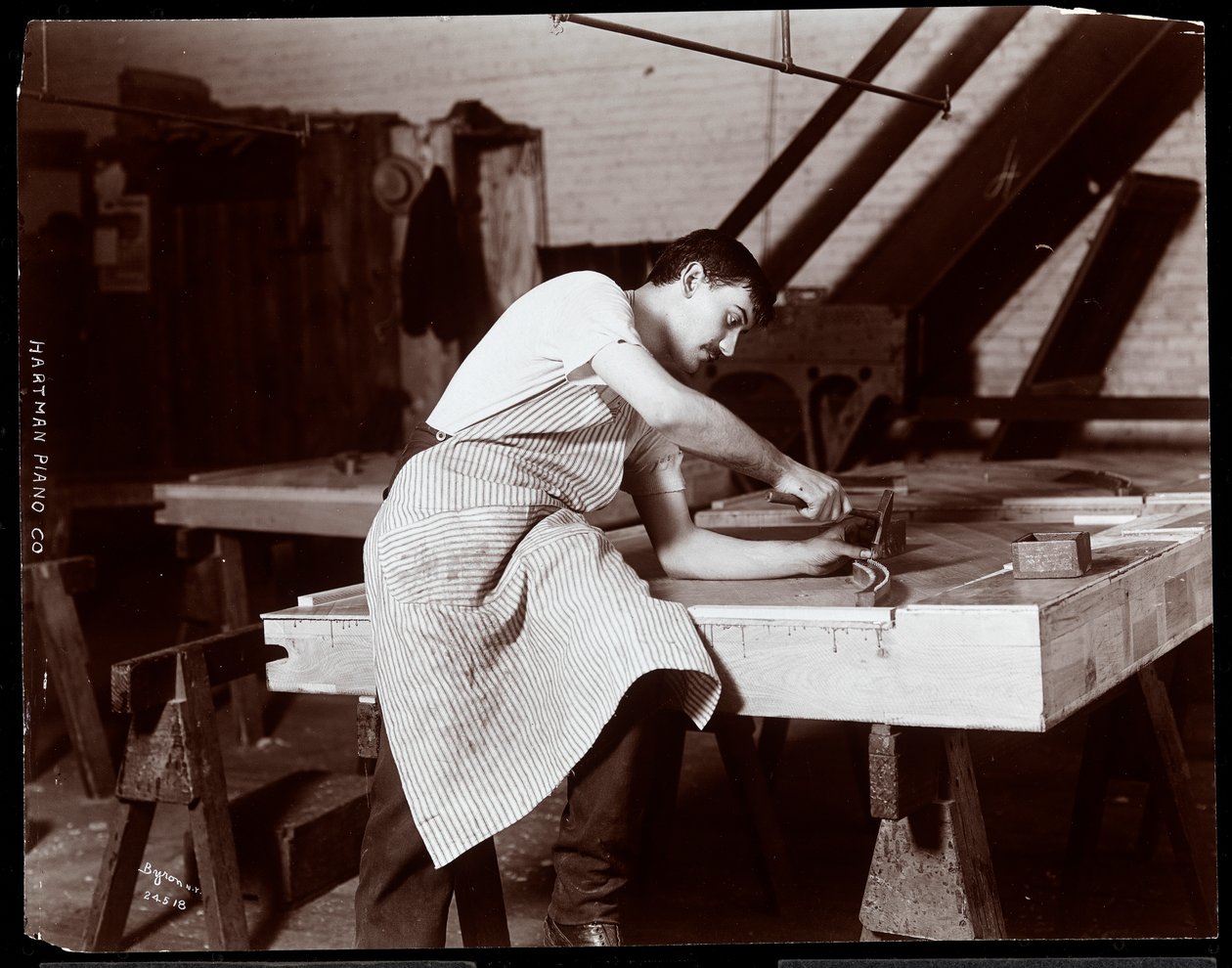 Hombre trabajando en la fábrica de pianos Hardman, Peck y Co., Nueva York, 1907 de Byron Company