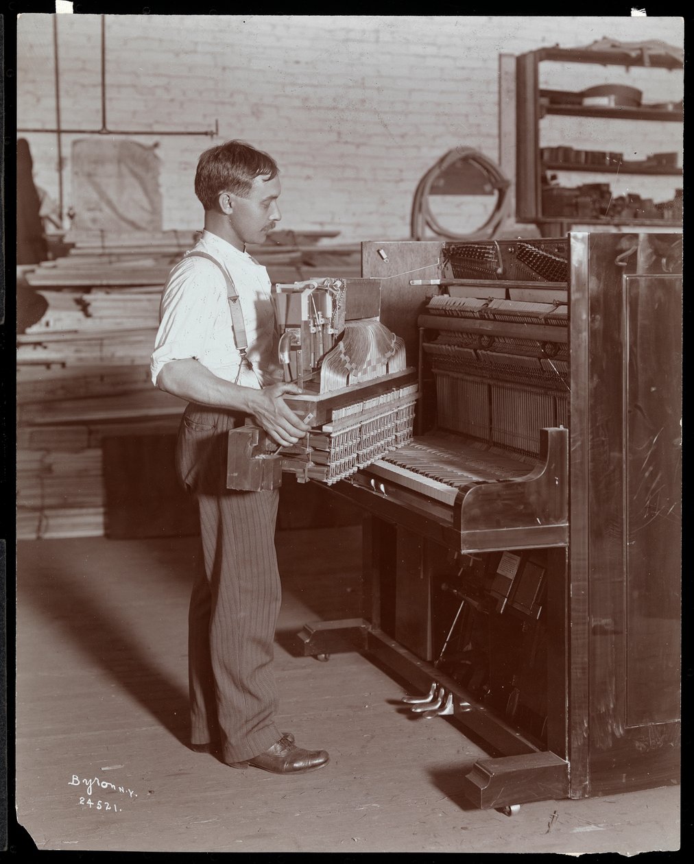 Hombre trabajando en la fábrica de pianos Hardman, Peck y Co., Nueva York, 1907 de Byron Company