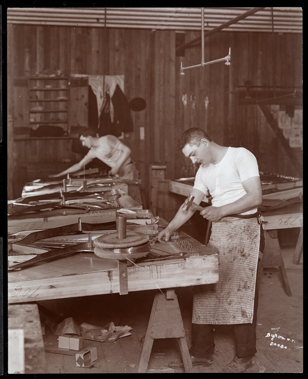 Dos hombres trabajando en la fábrica de Harrington Piano Co., 1907 de Byron Company