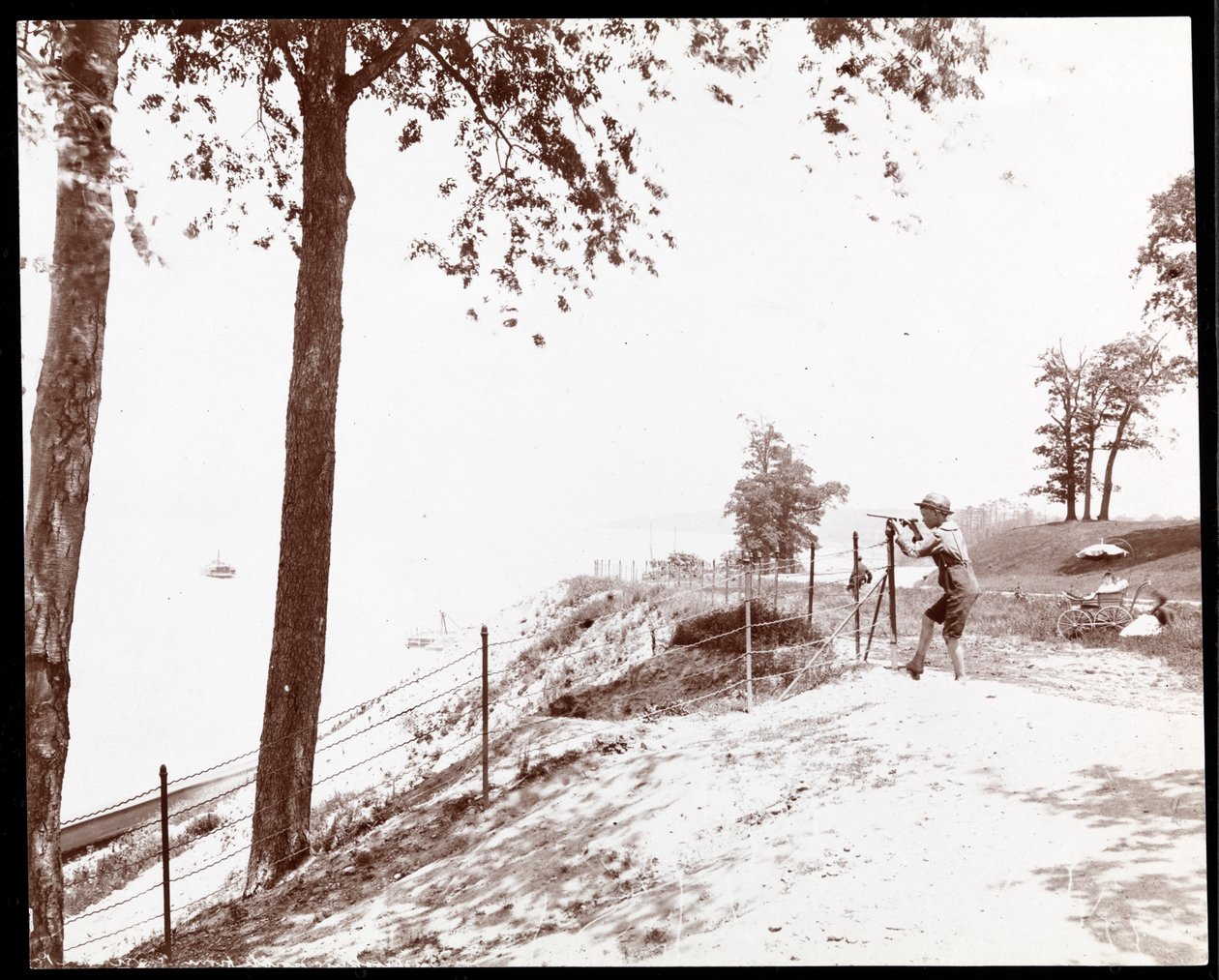 Vista de un niño con un catalejo mirando hacia el río Hudson desde Riverside Park, Nueva York de Byron Company