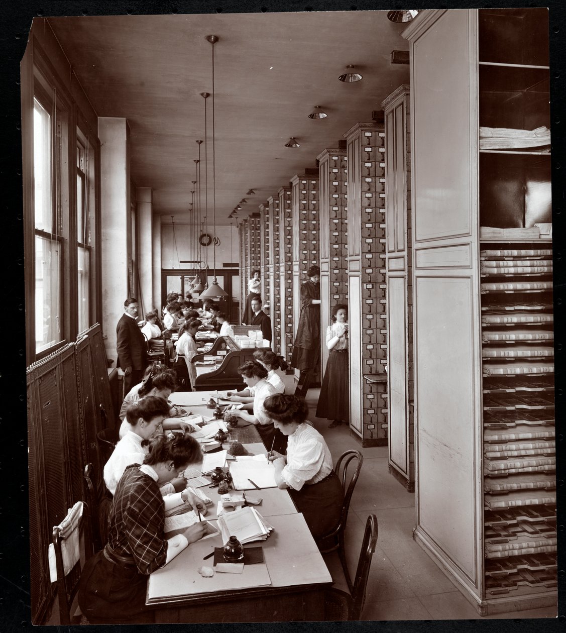 Mujeres trabajando en una sala de archivos, bajo supervisión masculina, en la Metropolitan Life Insurance Co. en la calle 23 y la avenida Madison, Nueva York, 1907 de Byron Company