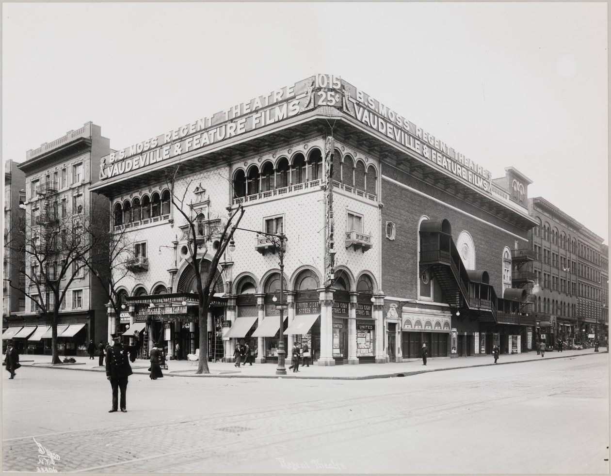 Un gran teatro con una fachada elaborada, completa con arcos moriscos y balcones. Un gran cartel en la parte superior del edificio dice 