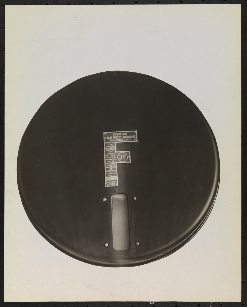 Máquina de alimentación de películas Feaster para discos de fonógrafo, recortada o enmascarada para producir un fondo en blanco de Company Byron