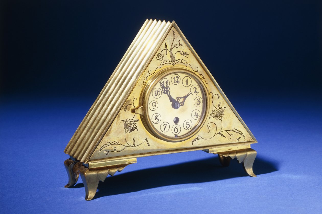 Un reloj de mesa triangular de latón con decoración floral grabada de Dagobert (attr. to) Peche
