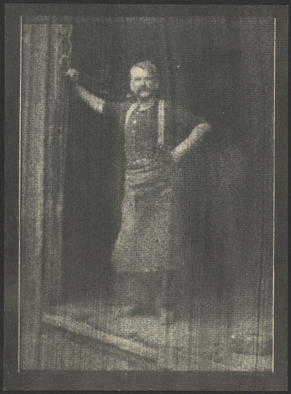 [Herrero de pie en la puerta, pipa en la boca] de Doris Ulmann