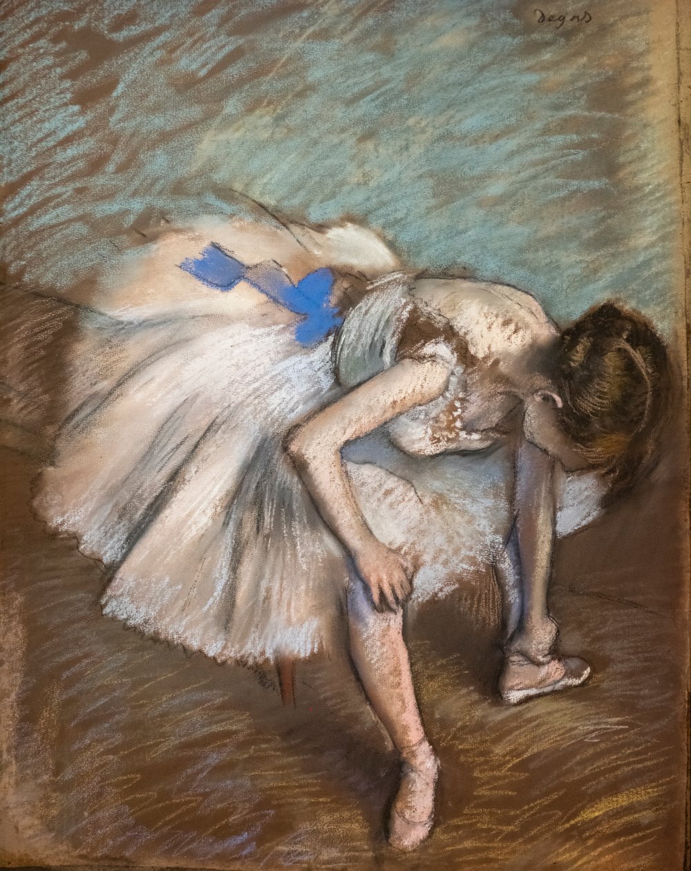 Bailarina sentada masajeando su pie. 1881-1883. Pastel sobre papel marrón pegado en cartón. de Edgar Degas