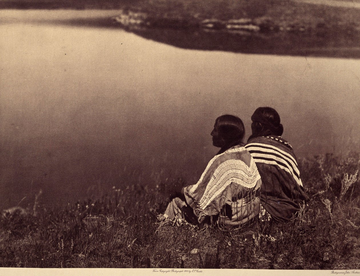 Una hora ociosa - Un momento de tranquilidad: Indios piegan sentados al borde de una masa de agua. Fotografía tomada del volumen 6 de la enciclopedia publicada por Edward S. Curtis (1868-1952) sobre los indios de Norteamérica, con prólogo de Theodore Roose de Edward Sheriff Curtis