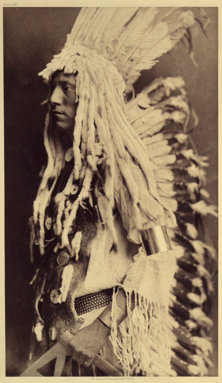 Persona mayor, Piegan. Los jóvenes no desaprovechan ninguna ocasión de fiesta pública para ponerse las ropas de su padre guerrero. Foto tomada del volumen 6 de la enciclopedia publicada por Edward S. Curtis (1868-1952) sobre los indios de América del Norte de Edward Sheriff Curtis