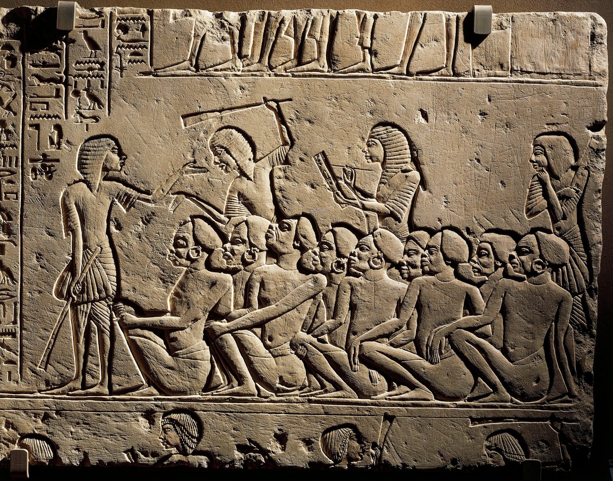 Un grupo de prisioneros negroides rodeados por guardias armados con garrotes mientras un escriba redacta un informe, relieve de la tumba de Horemheb en Saqqara. de Egyptian 18th Dynasty