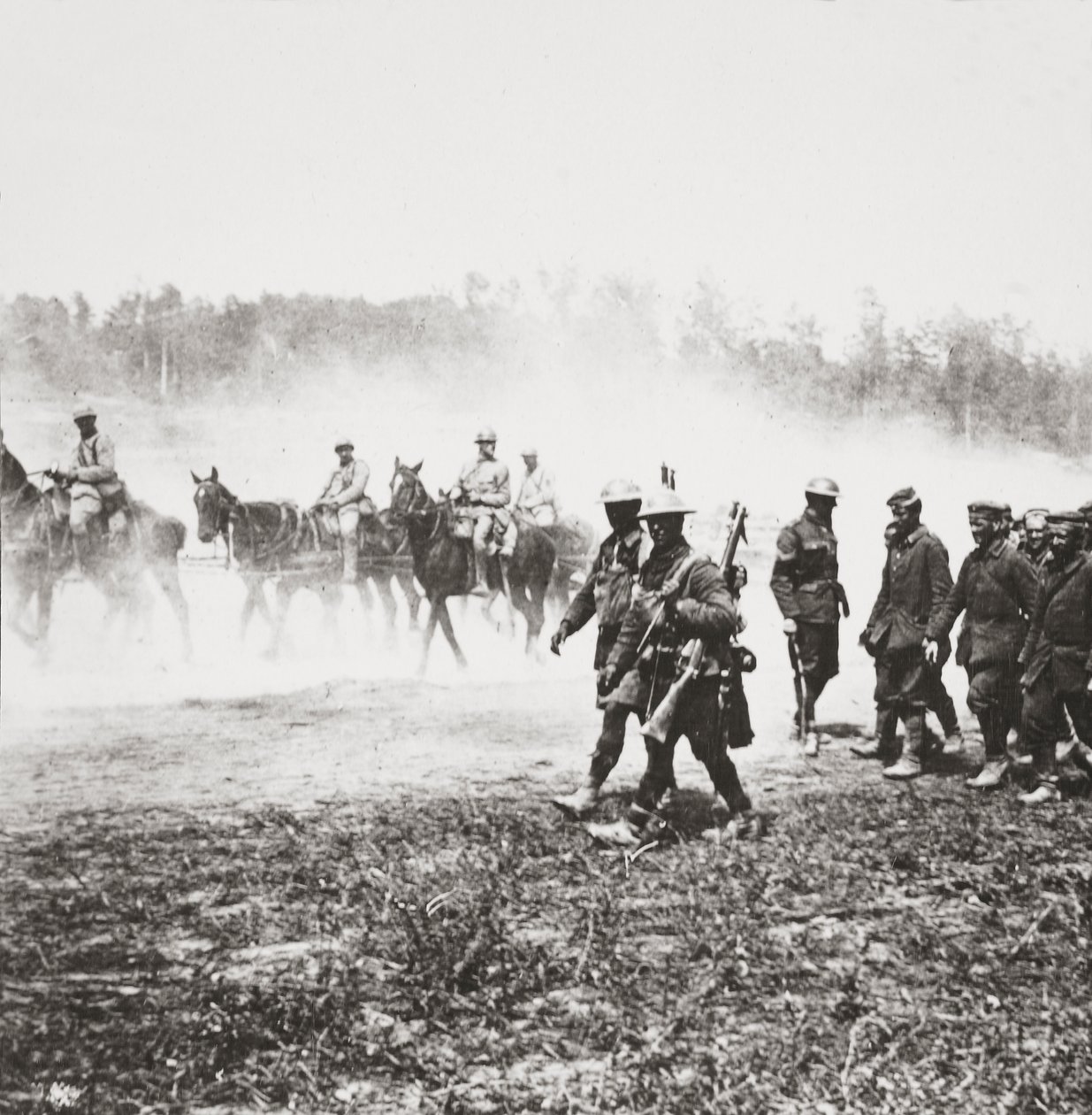 Los cañones franceses 75 regresando a Chemin des Dames pasan prisioneros capturados en nuestra ofensiva cerca de St Quentin de English Photographer